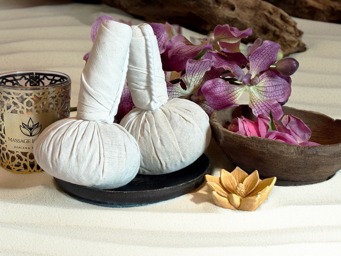 Kräuterstempel, Orchideen und Kerze mit dem Logo von Massage Essence